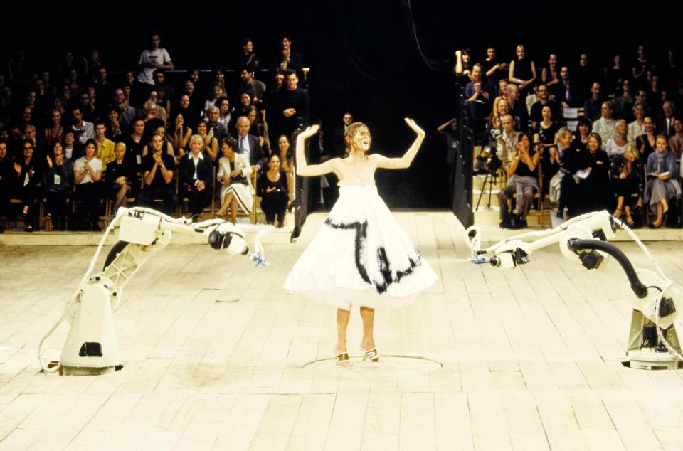  Model Shalom Harlow is sprayed with paint by robots during the finale of the Alexander McQueen show in 1999