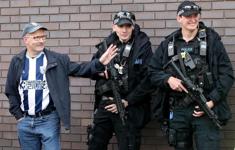  Armed police with a West Brom Albion fan outside The Hawthorns today