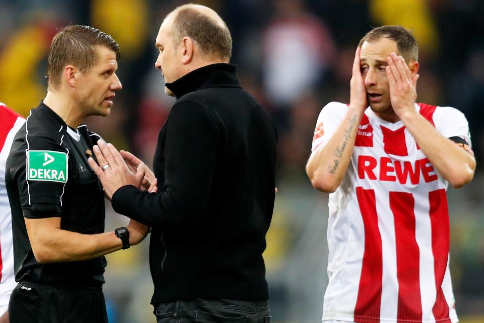  Cologne's Joerg Schmadtke argues with the official