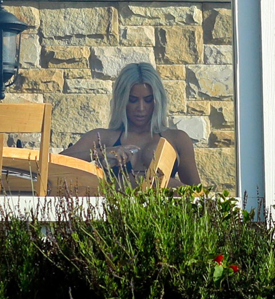  Kim applied cream to her chest while sitting in the shade