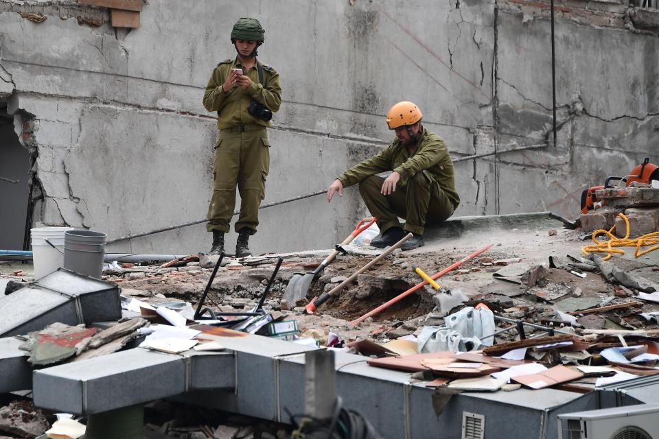  Rescuers from Israel join the search for survivors in a flattened building