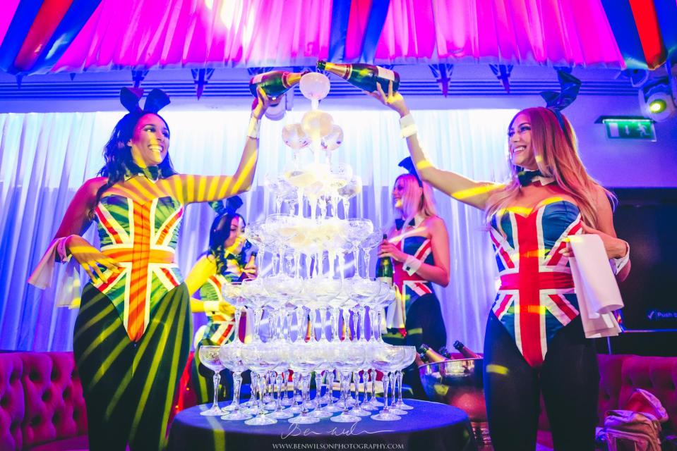  Natalie, left, and a bunny pal create a champagne tower during one of the club's lavish events