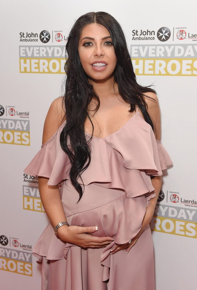  Cara De La Hoyde hugs her baby bump