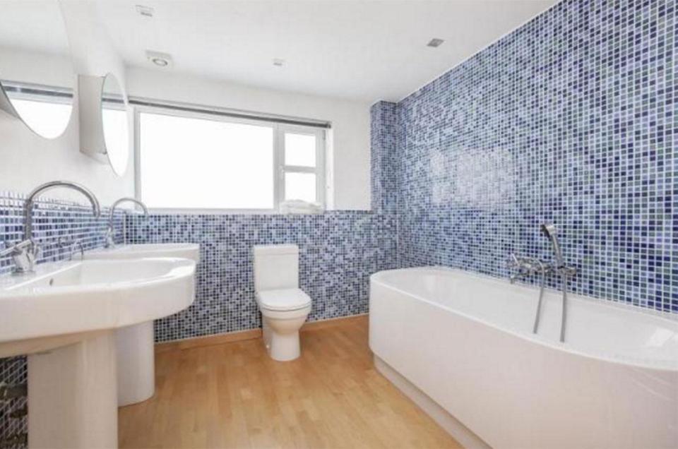  One of the three bathrooms is tiled in shades of blue