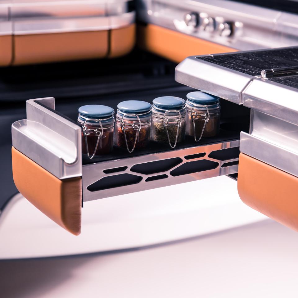  The fold-out bench top has a sliding spice rack, sink and gas hobs