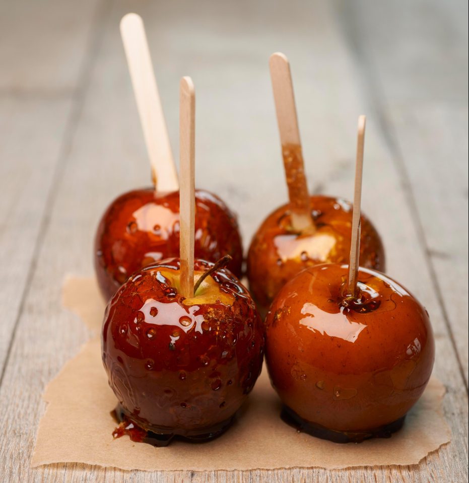  Add lolly sticks into apples to start off making your toffee apple treats