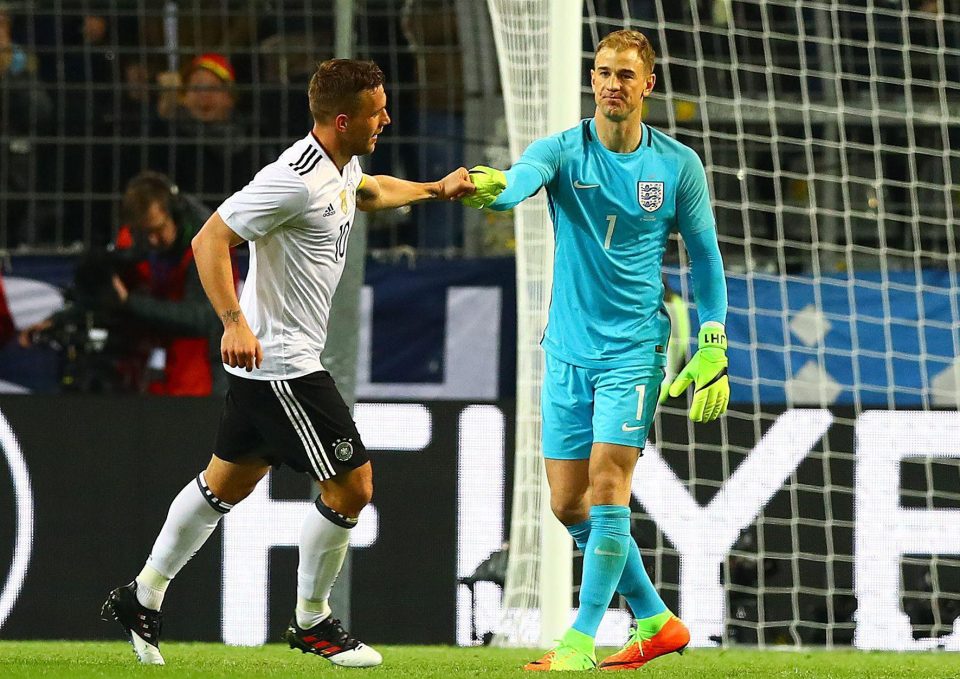 Podolski gets a glove punch from England keeper Joe Hart