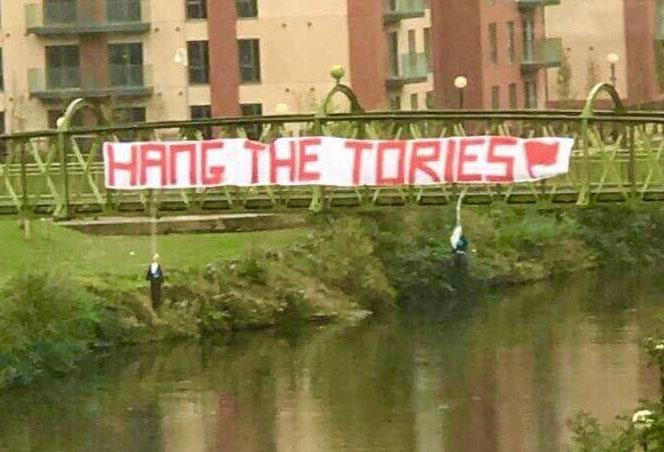  Effigies are hung from a bridge in Manchester as Tories go to city for conference