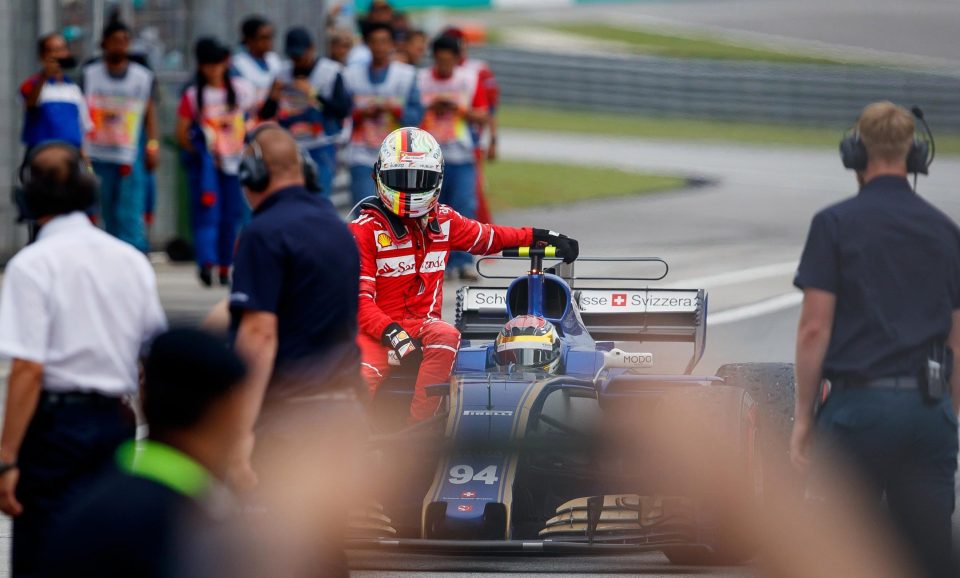  Sebastian Vettel rolls in after catching a lift to the pits following a post-race smash