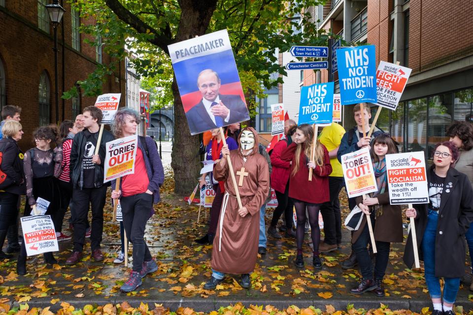  An estimated 50,000 protesters marched through Manchester city centre - including a bizarre masked Putin supporter