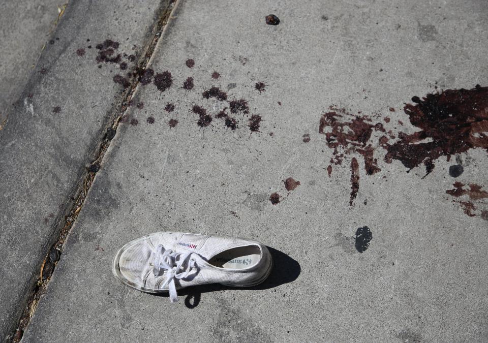  Blood stains and a discarded shoe lie in the street in the aftermath of the atrocity