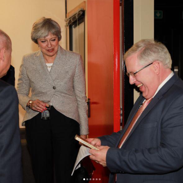  Theresa May looks on as Patrick McLoughlin has a laugh