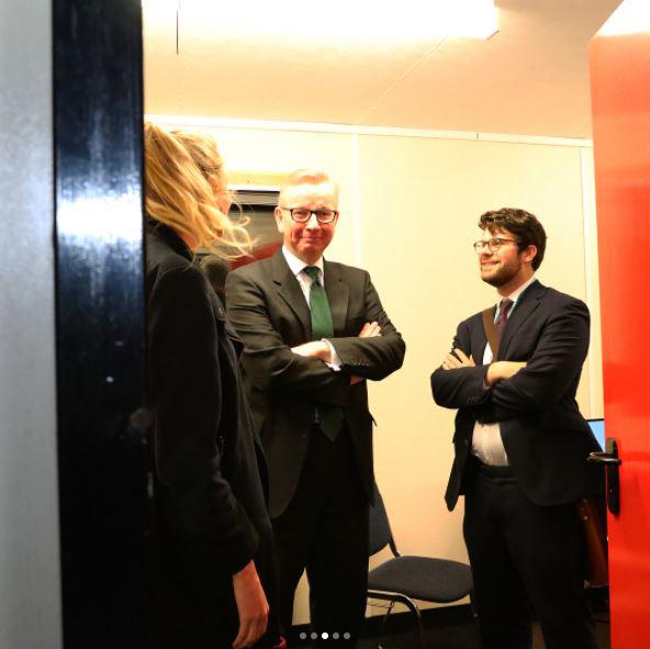  A smirking Michael Gove is spotted in a meeting room with advisers