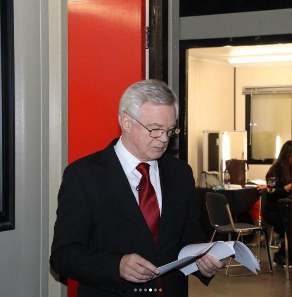  David Davis is stern-faced as he reads through a document