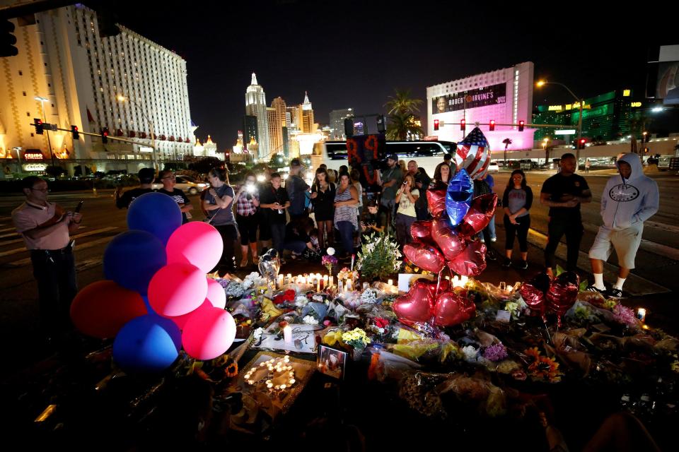  People gather at a makeshift memorial in the middle of Las Vegas Boulevard