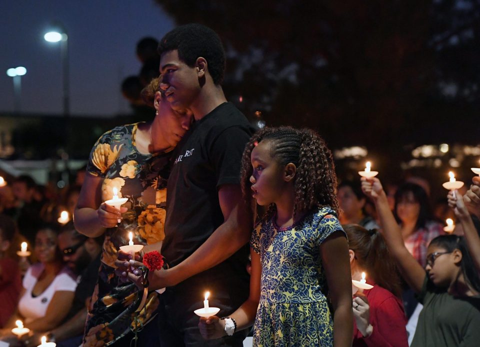  Veronica Hartfield, widow of slain police officer Charleston Hartfield, with their son Ayzayah, 15, and daughter Savannah, 9, at a vigil