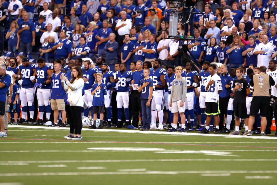  Indianapolis Colts players and personnel stand during the playing of the National Anthem before the game