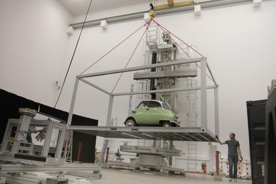 The 1962 BMW Isetta Gesamt 250 is being lifted into position