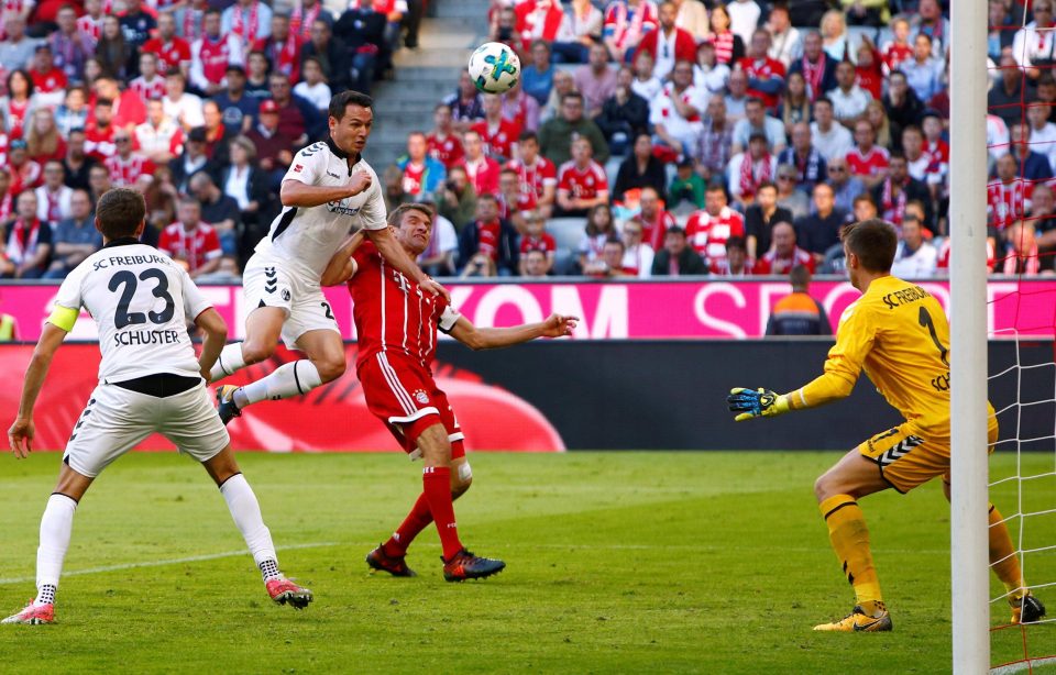 Bayern Munich striker Thomas Muller causes problems for Freiburg duo Julian Schuster and Nicolas Hofler