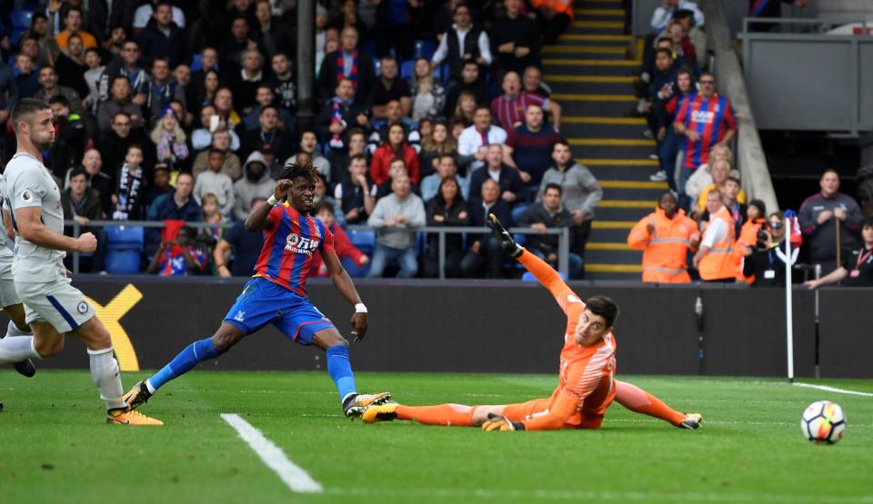  Wilfried Zaha curls his shot past Thibaut Courtois to put Palace 2-1 up