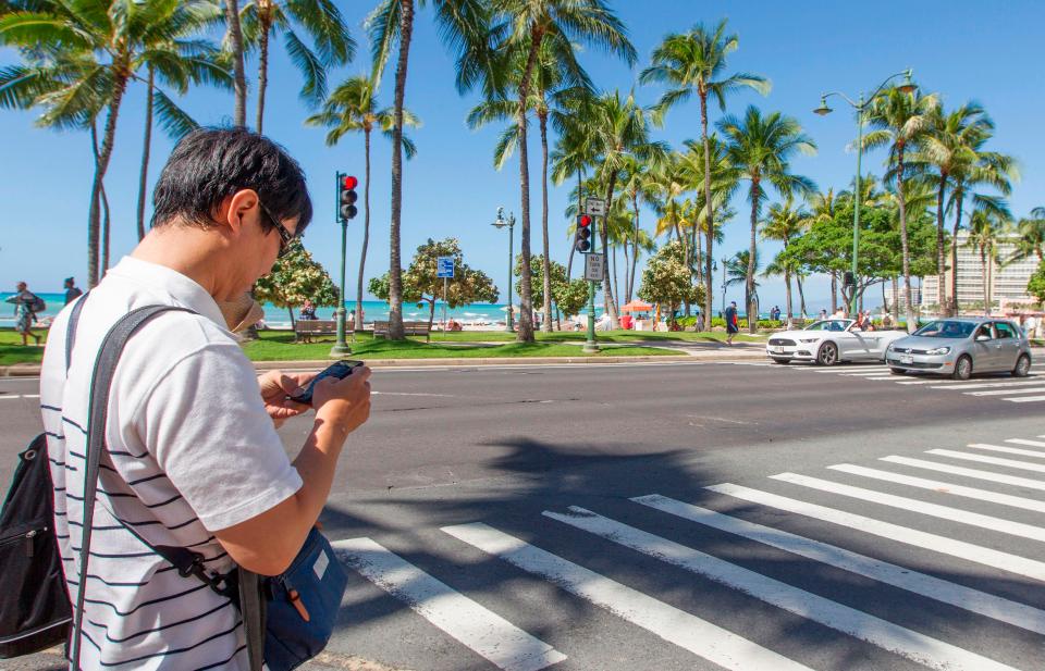 People can be slapped with a £26 fine for texting while crossing the street in Honolulu 