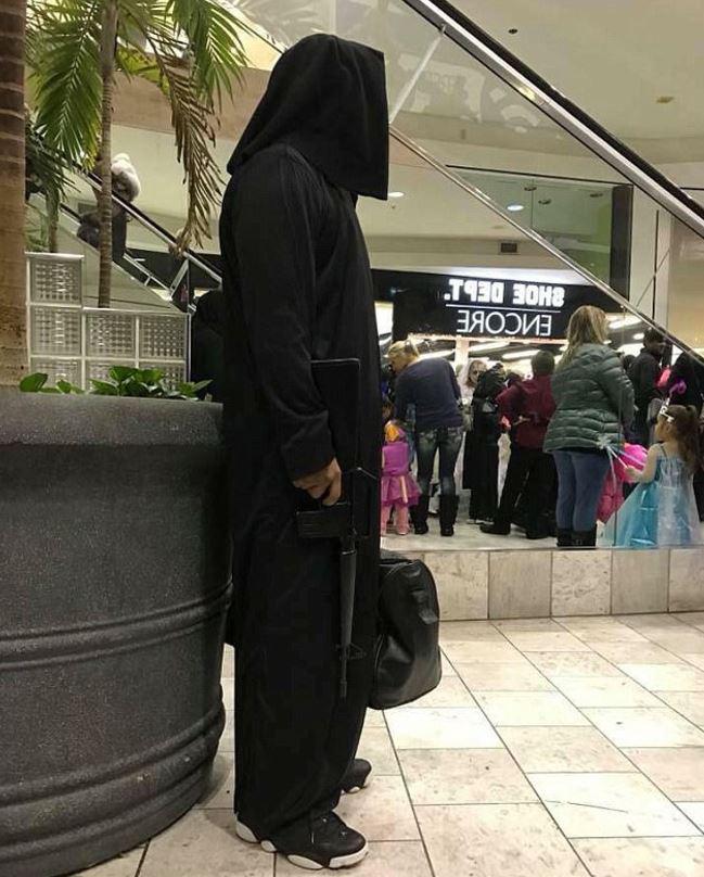  This photo of a man in an all-black costume holding a duffle bag and gun called his outfit insensitive in light of recent shootings