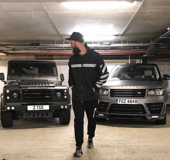  Tom poses in front of two custom-built Defenders