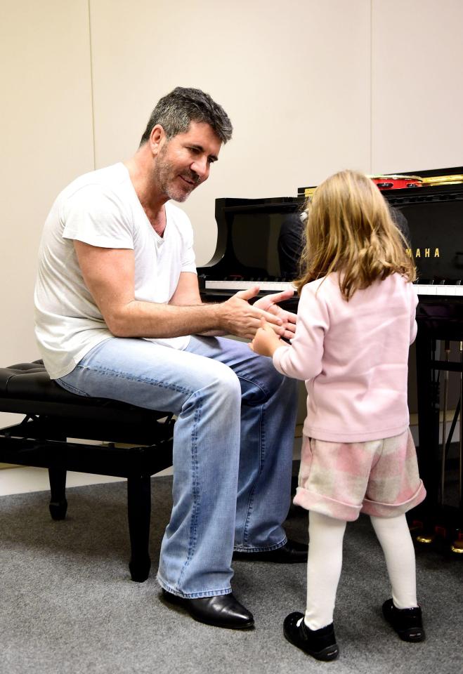  Simon chats with a 4-year-old during a visit to The Brit School and the Nordoff Robbins facility back in 2015