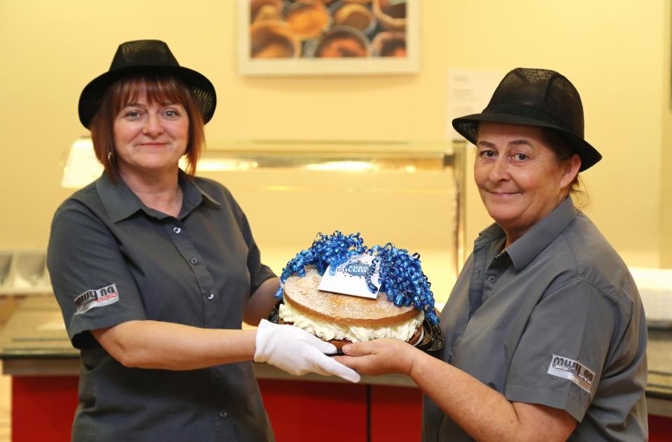 The winners' colleagues presenting a congratulatory cake