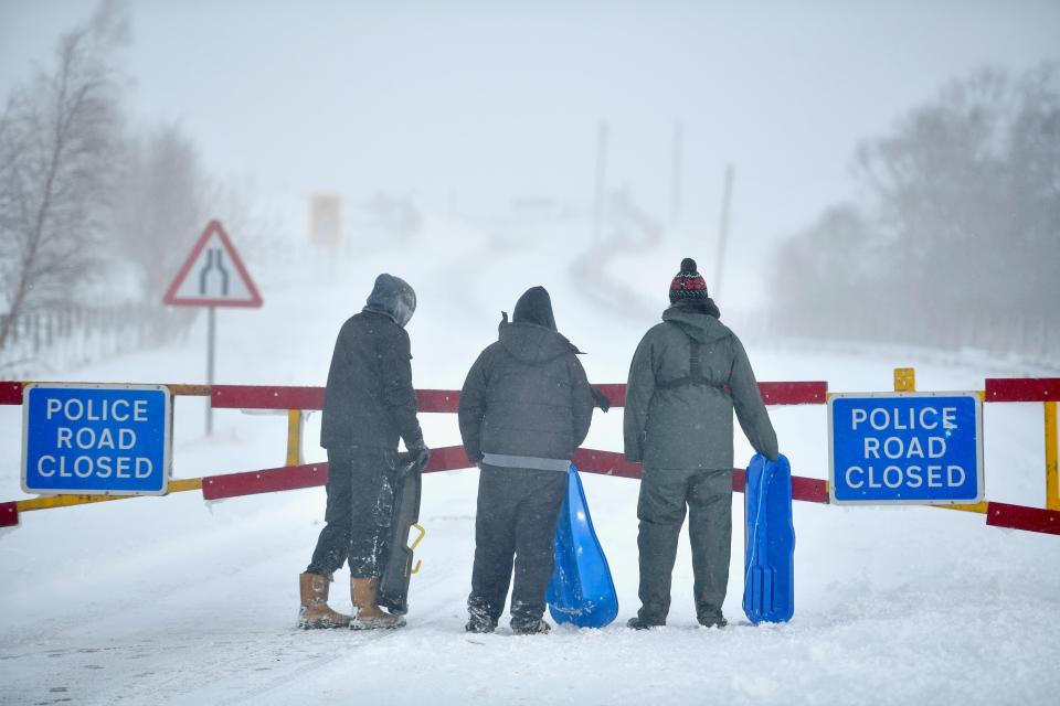  People stand with snow sledges behind the closed snow gates on the A93 on January 13, 2017 in Spital of Glenshee