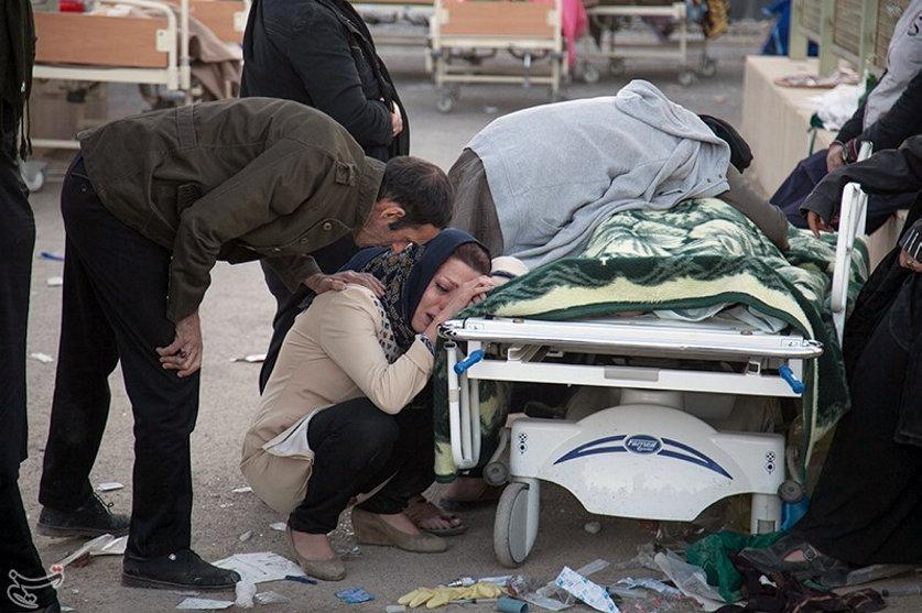  A woman crouches beside a victim of the quake