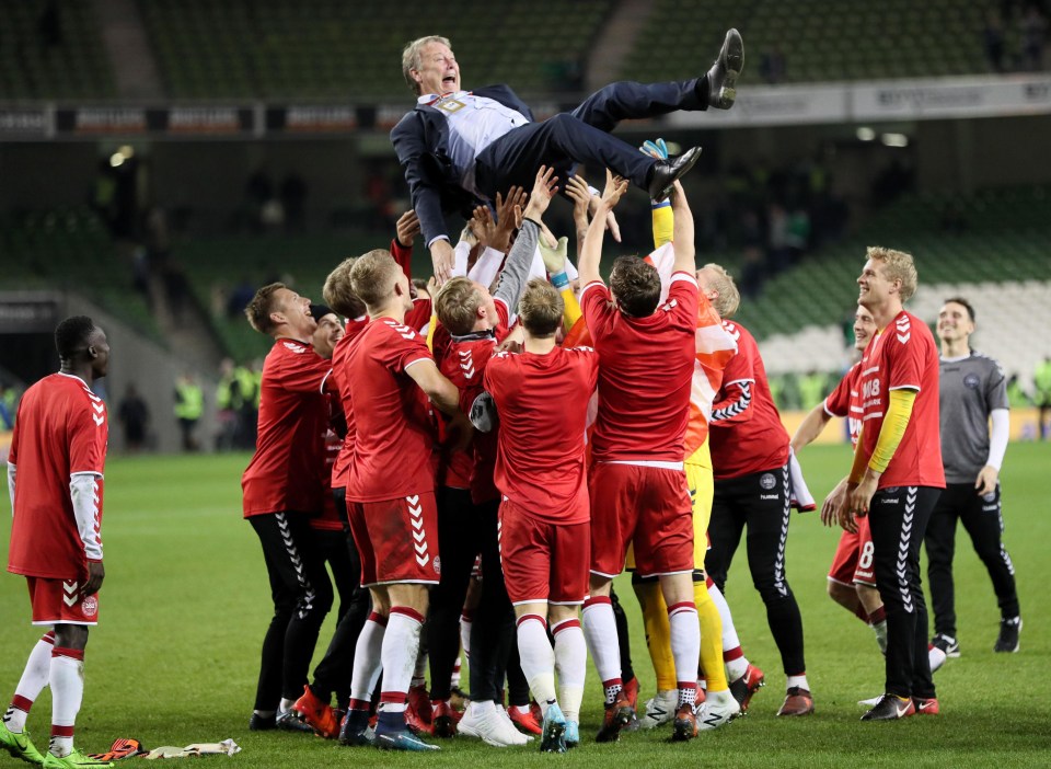 Denmark hoist their coach Age Hareide into the air as they reach the World Cup Finals