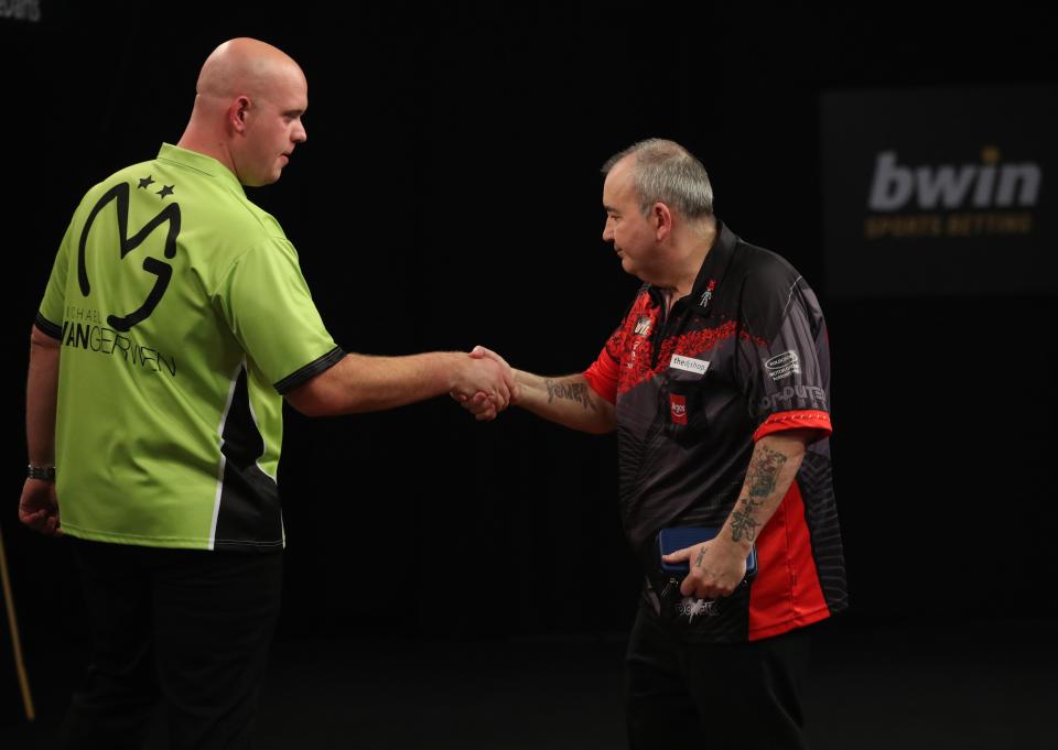  Michael van Gerwen and Phil Taylor have a tense handshake following the conclusion of their match