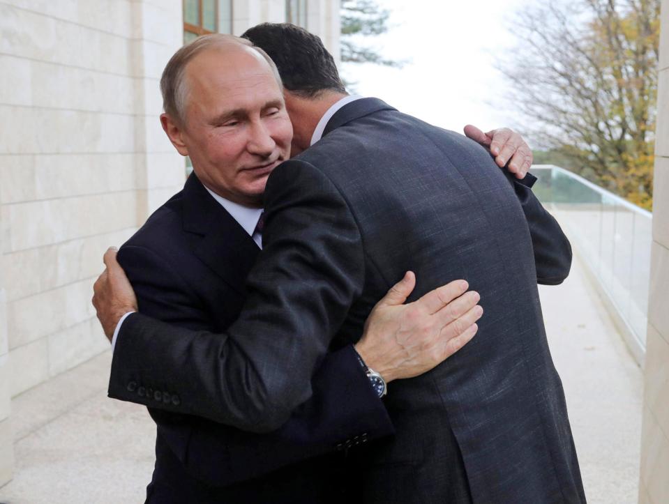 Putin and Assad share a hug at a meeting in Russia