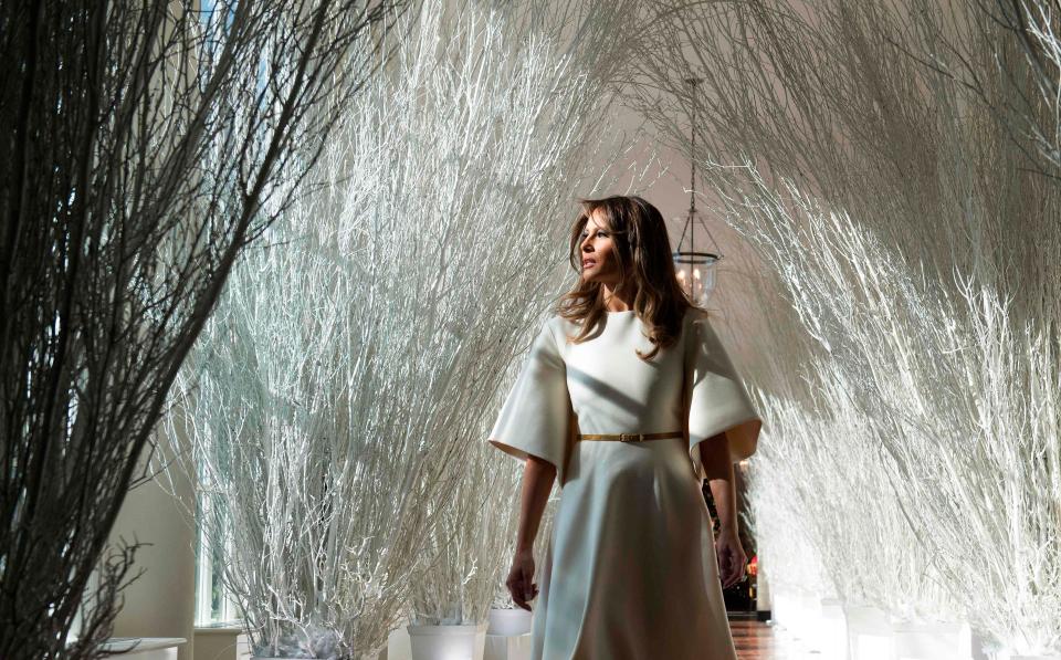  Melania inspects the decorations in a hallway