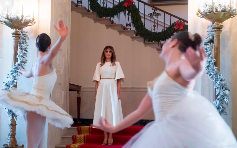  Melania stood on a bright red carpet with gold trim as she waited for a pair of ballet dancers