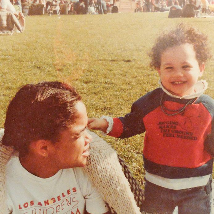  A young Meghan, pictured with her mum, shows off her natural curls with a cheeky grin