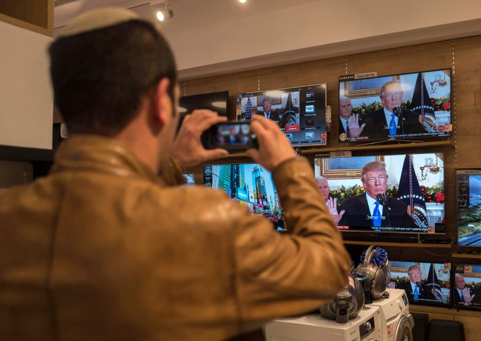  Bystanders in Tel Aviv watch as Donald Trump declares US recognition of Jerusalem as Israel's capital