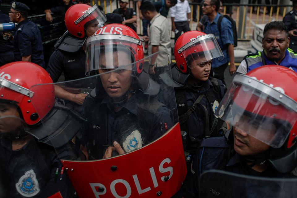  Royal Malaysian Police stand guard in front of the country's US embassy during a rally