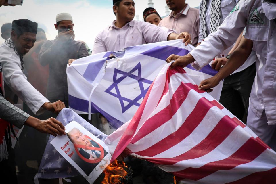  Flags and pictures of Donald Trump are burnt during protests in Indonesia