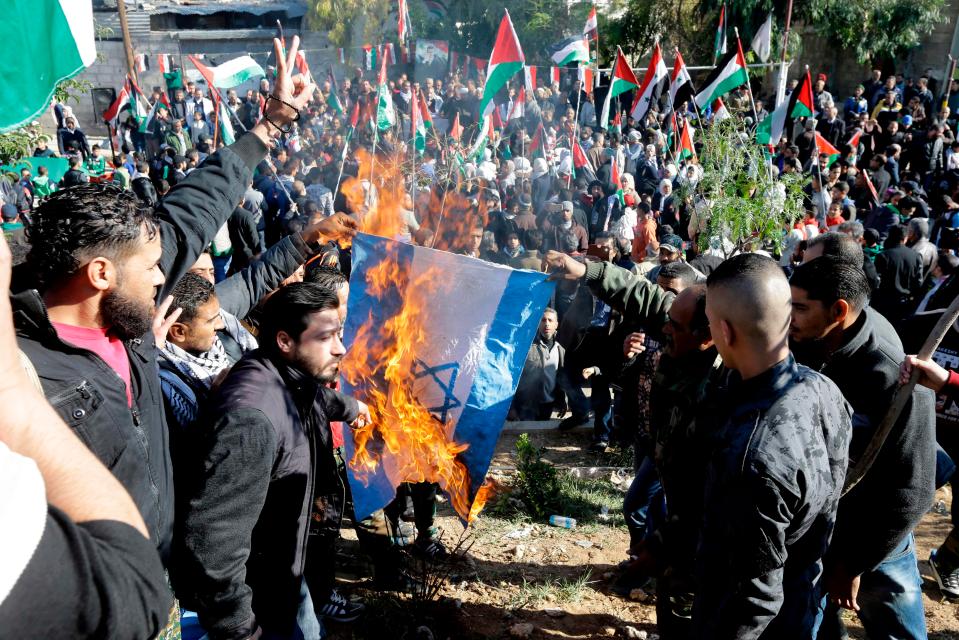  Palestinians burn an Israeli flag during a demonstration in Damascus, Syria