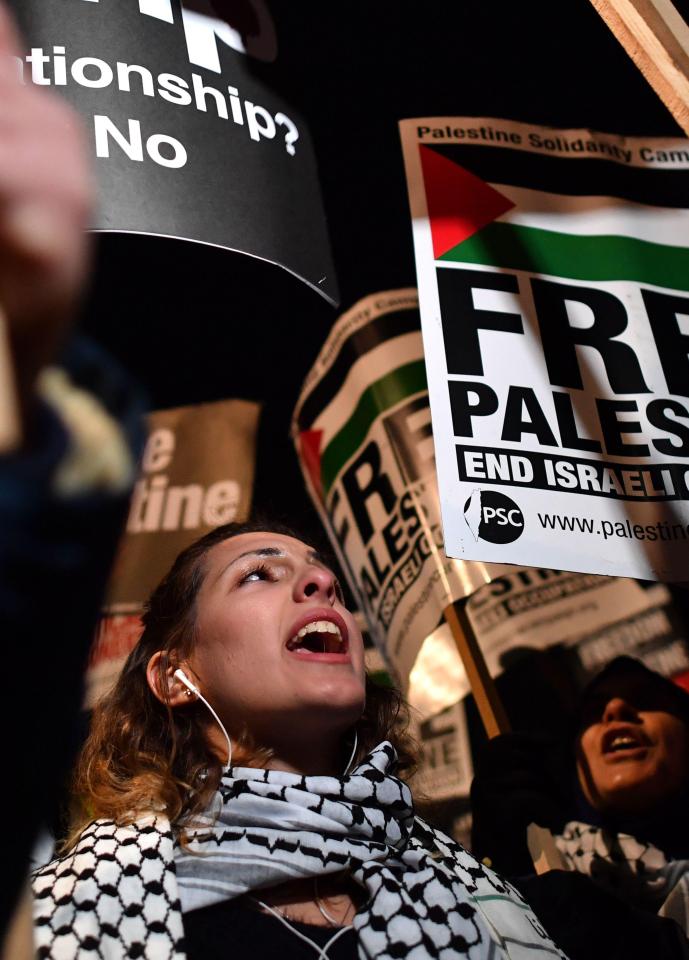  Protesters hold up placards as they gather outside the US Embassy in London