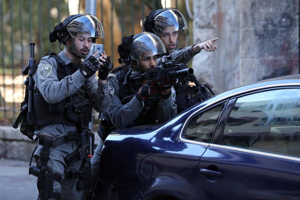  An Israeli policeman aims his weapon during a demonstration in east Jerusalem today