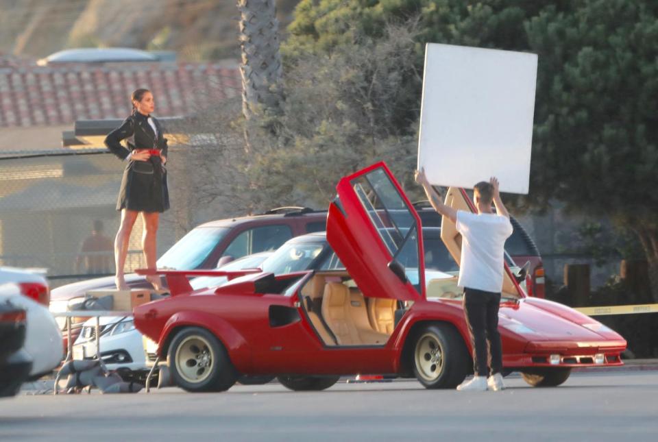  Standing on the red sports car during the photoshoot