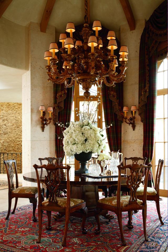  A table for seven decorated with flowers right below an exquisite chandelier inside the $250 million property