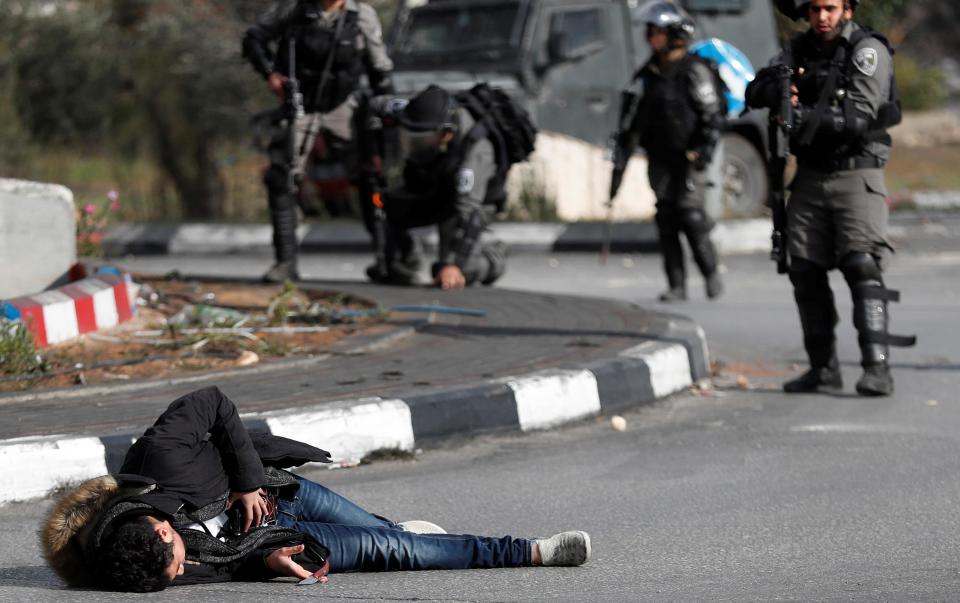 A knife can be seen in the man's hand as cops cautiously approach him