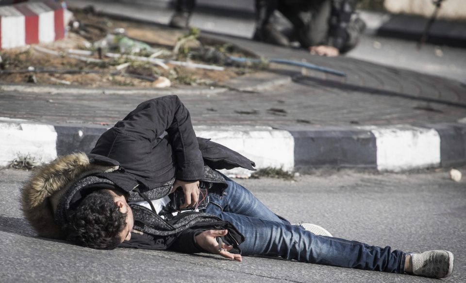 The man is seen lying on the floor after being shot by Israeli cops 