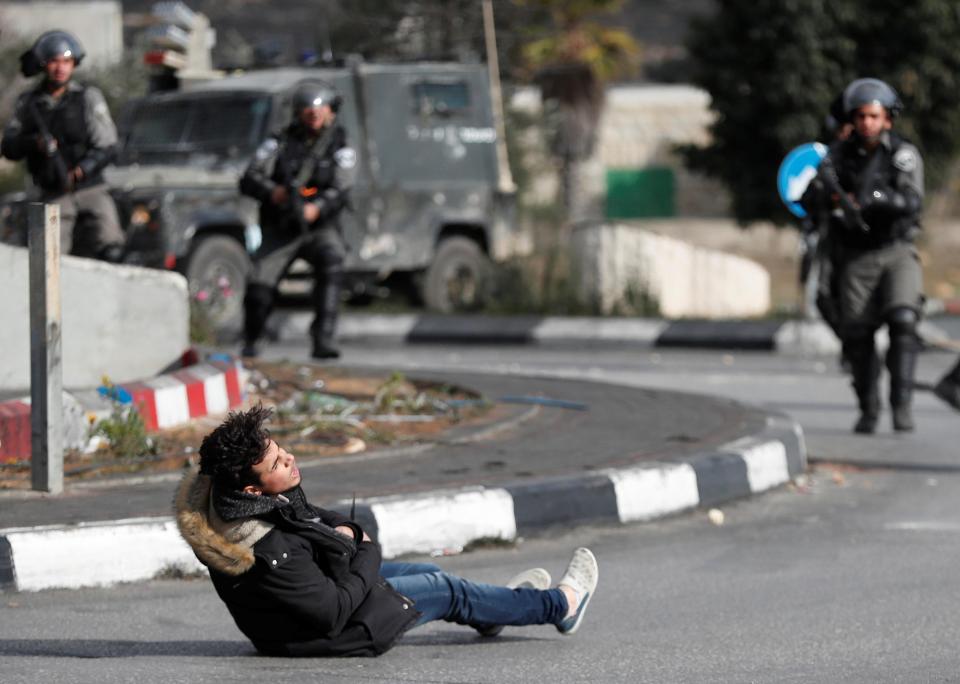 The knifeman drops to the ground after being shot by Israeli soldiers