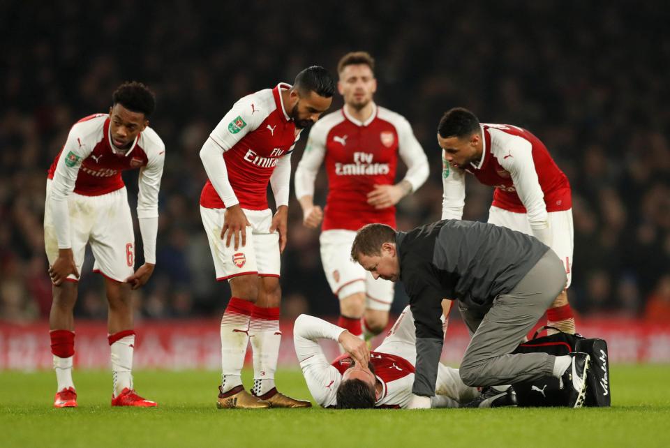  Arsenal stars surround Olivier Giroud as a physio tends to his hamstring injury