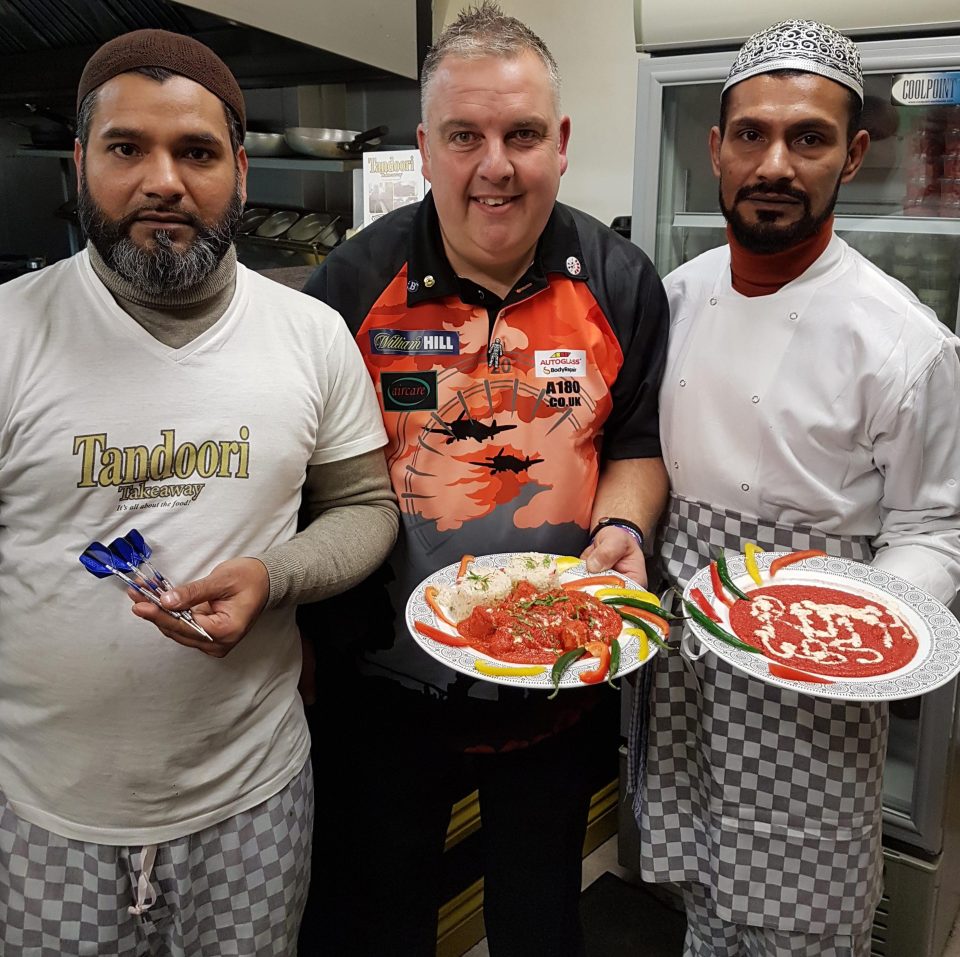 James Richardson shows he loves curries as much as darts as he meets staff at the takeaway in Higham Ferrers, Northamptonshire